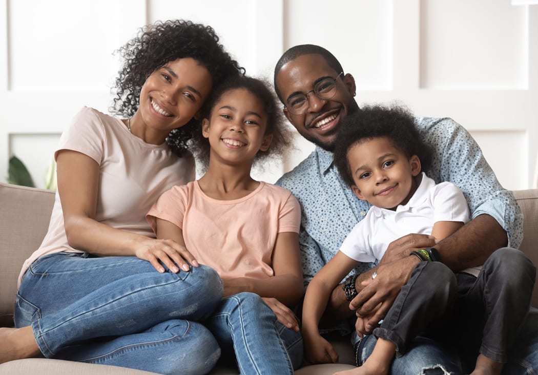 Portrait of happy black family with kids relax on couch