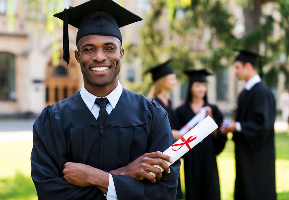 Happy African man in graduation gowns holding diploma